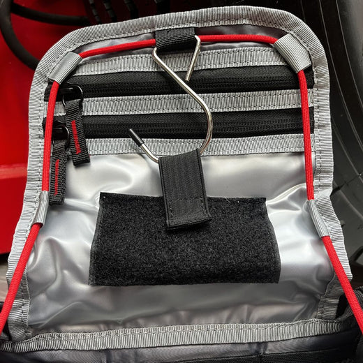 Détail des zips à tirette rouge et des bandes réfléchissantes de la trousse FFP